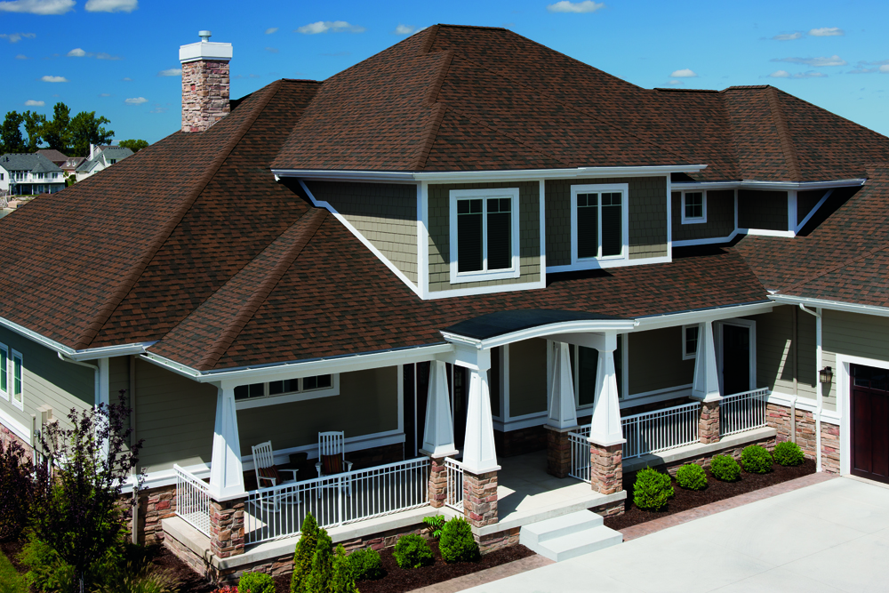 Gray asphalt shingle roof with a dormer window on a sunny day.